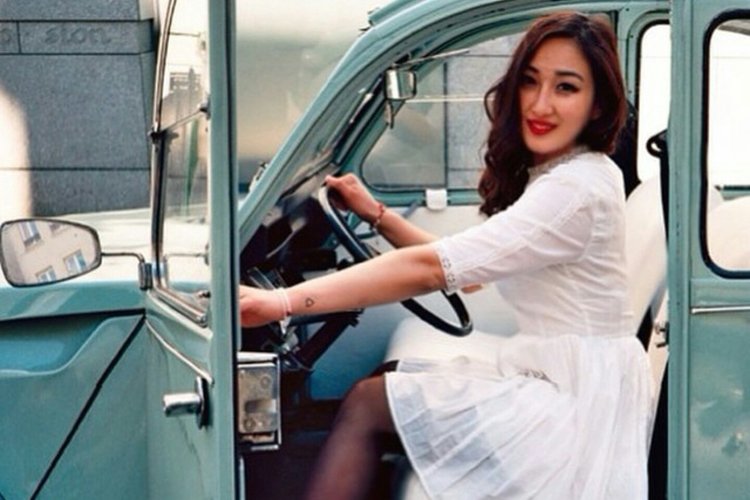 Femme en robe de mariée dans une 2cv Citroën