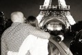 Pareja bajo la Torre Eiffel por la noche